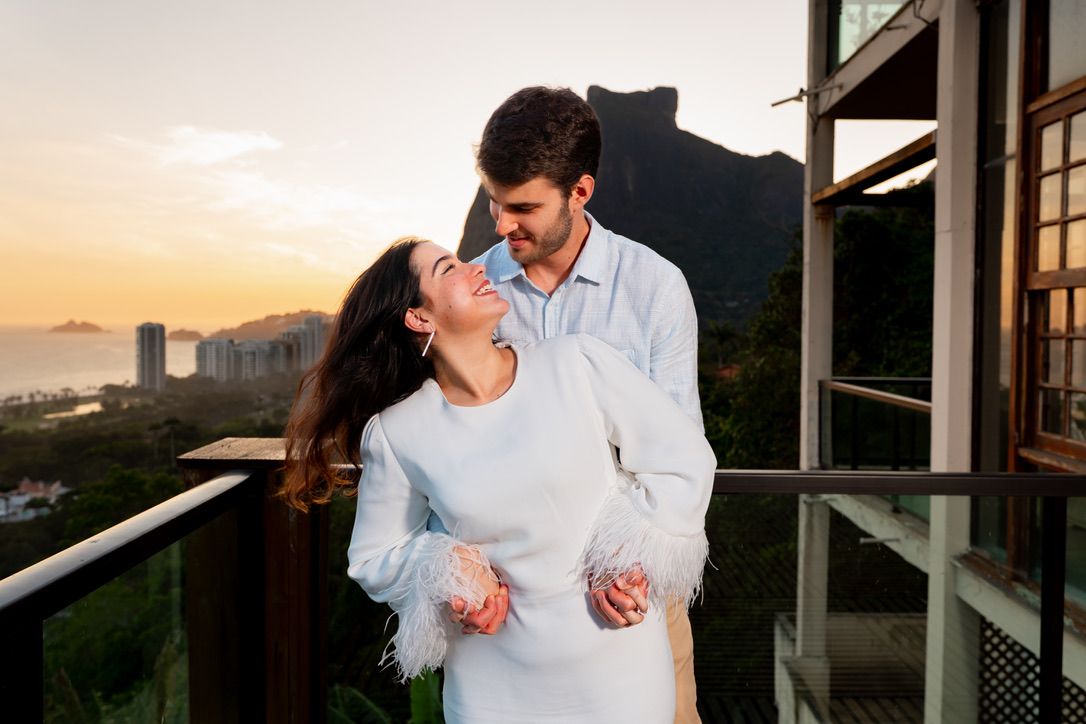 Maria Isabella e Eric rindo na varanda ao pôr do sol