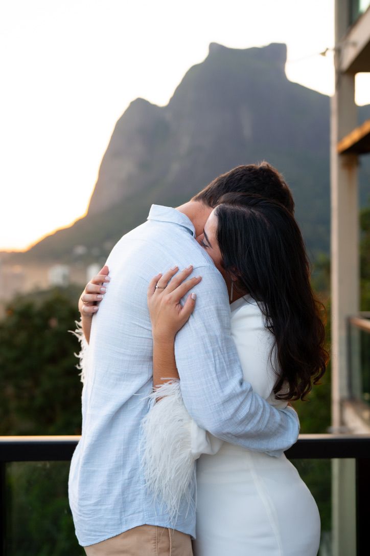 Maria Isabella e Eric abraçados com a Pedra da Gávea ao fundo